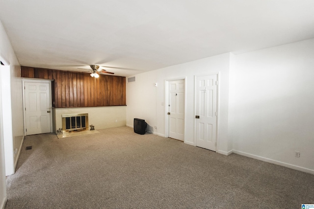 unfurnished living room featuring visible vents, ceiling fan, carpet flooring, a brick fireplace, and baseboards