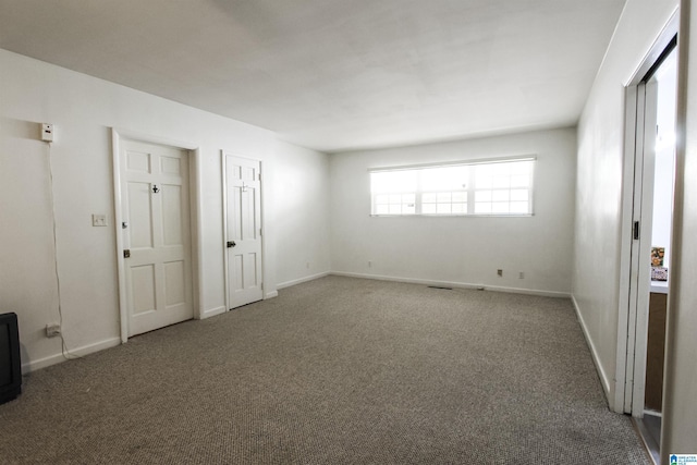 carpeted empty room with baseboards
