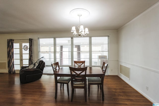 dining room with a chandelier, wood finished floors, and ornamental molding
