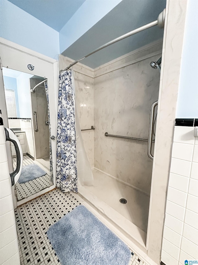 full bath featuring tile patterned flooring and a shower stall