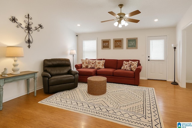 living area featuring ceiling fan, a healthy amount of sunlight, and wood finished floors