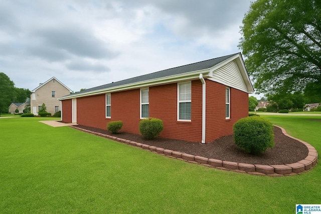 view of property exterior with a lawn and brick siding