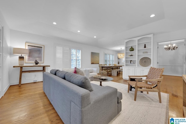 living room featuring a chandelier, light wood finished floors, recessed lighting, and baseboards