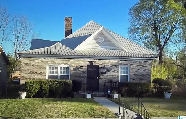 2121 47th Pl, Birmingham, AL 35208 - view of front of home with metal roof, a front lawn, a standing seam roof, and a chimney