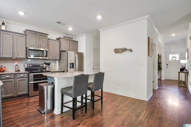 1064 Timberline Rdg, Calera, AL 35040 - kitchen featuring tasteful backsplash, gray cabinets, a breakfast bar area, a center island, and appliances with stainless steel finishes