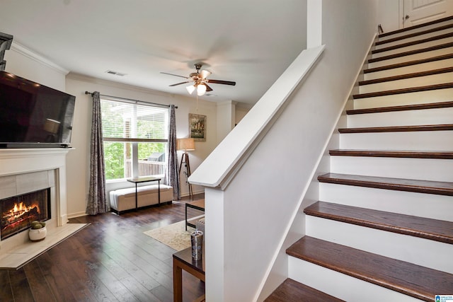 1064 Timberline Rdg, Calera, AL 35040 - stairway with ornamental molding, a tiled fireplace, ceiling fan, visible vents, and hardwood / wood-style flooring