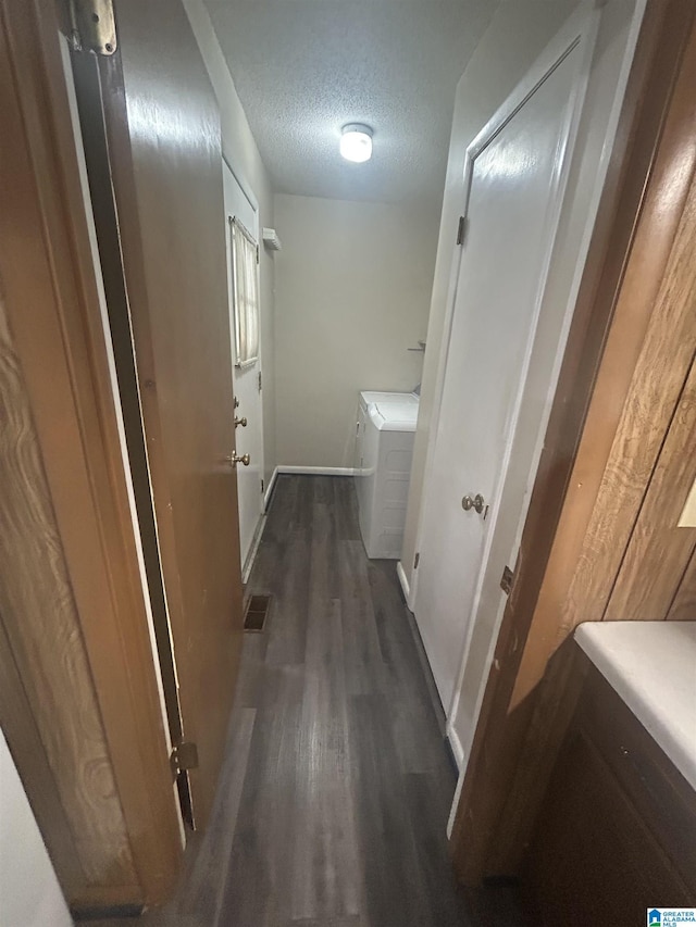 hall with washing machine and dryer, a textured ceiling, baseboards, and wood finished floors