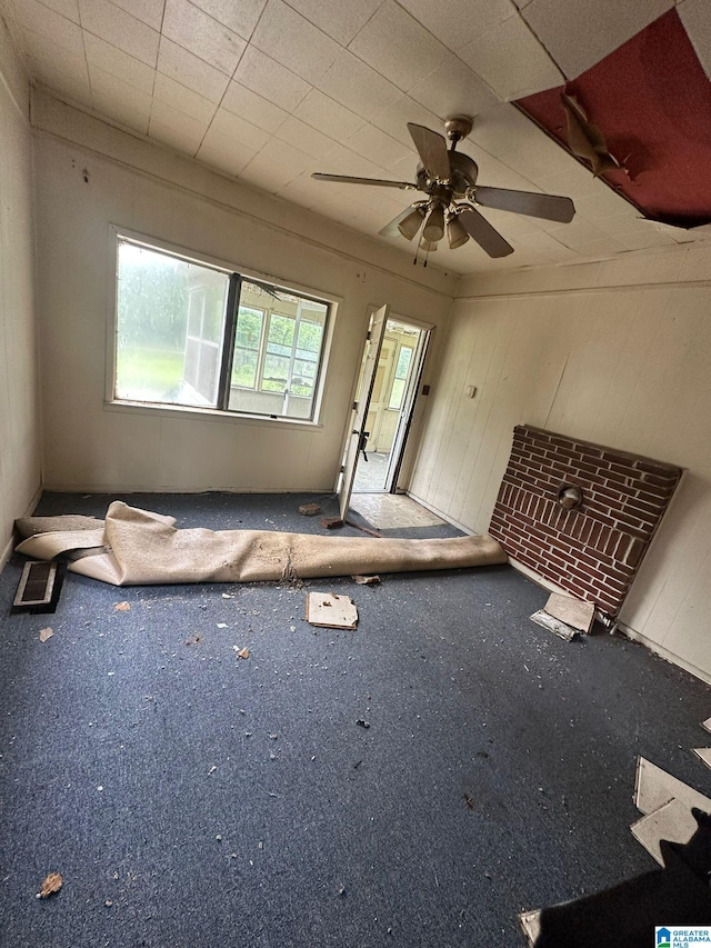 carpeted spare room featuring visible vents and ceiling fan