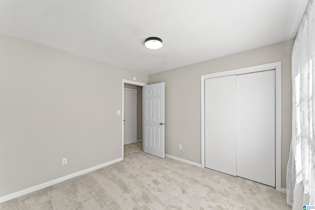 unfurnished bedroom with carpet floors, baseboards, and a closet