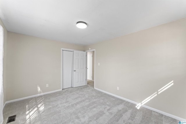 unfurnished bedroom with carpet flooring, a closet, visible vents, and baseboards