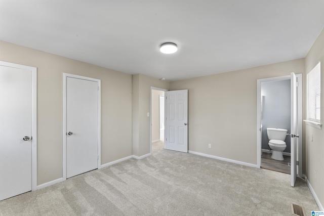 unfurnished bedroom featuring baseboards, carpet flooring, and connected bathroom