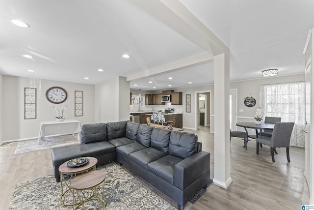 living room with baseboards, light wood-style flooring, and recessed lighting