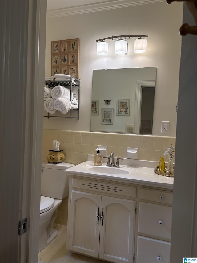 half bathroom featuring toilet, tile walls, tile patterned flooring, vanity, and ornamental molding