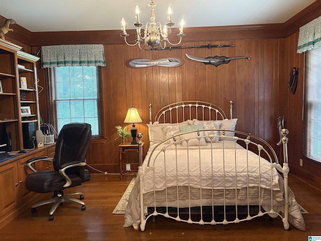 bedroom with wood walls, wood finished floors, ornamental molding, a chandelier, and baseboards