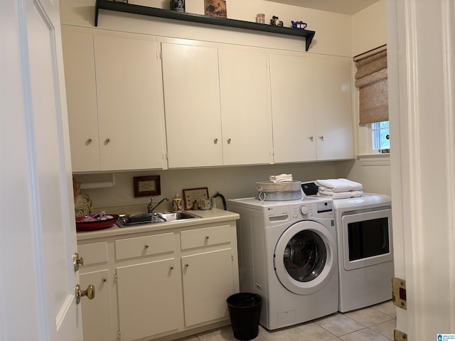 clothes washing area with independent washer and dryer, cabinet space, light tile patterned floors, and a sink
