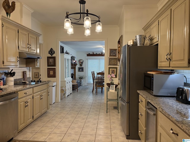 kitchen with ornamental molding, under cabinet range hood, backsplash, light tile patterned floors, and appliances with stainless steel finishes
