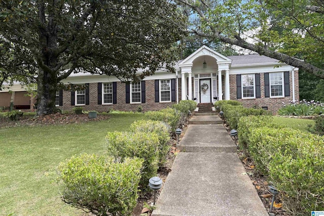 neoclassical / greek revival house featuring crawl space, brick siding, and a front yard