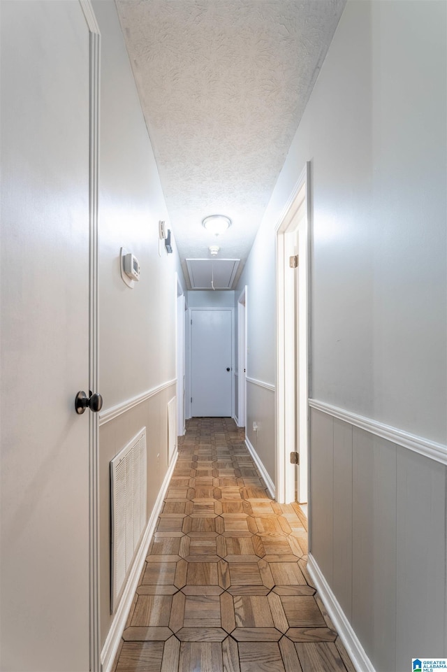 1111 Creek Trl, Anniston, AL 36206 - hallway with a textured ceiling, attic access, visible vents, and wainscoting