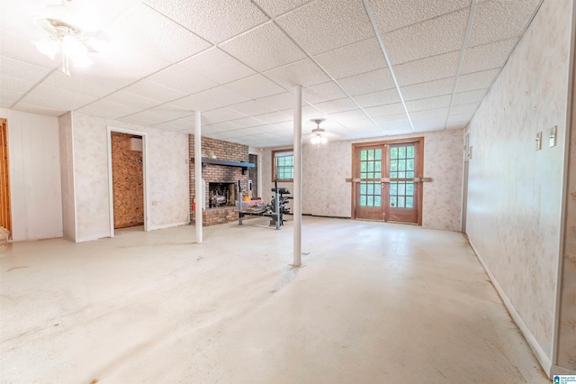1111 Creek Trl, Anniston, AL 36206 - basement featuring a paneled ceiling, a brick fireplace, french doors, and wallpapered walls