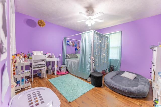 1111 Creek Trl, Anniston, AL 36206 - bedroom featuring a textured ceiling, a ceiling fan, and wood finished floors