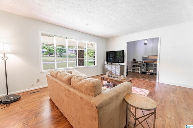 1111 Creek Trl, Anniston, AL 36206 - living area featuring a textured ceiling, visible vents, wood finished floors, and baseboards