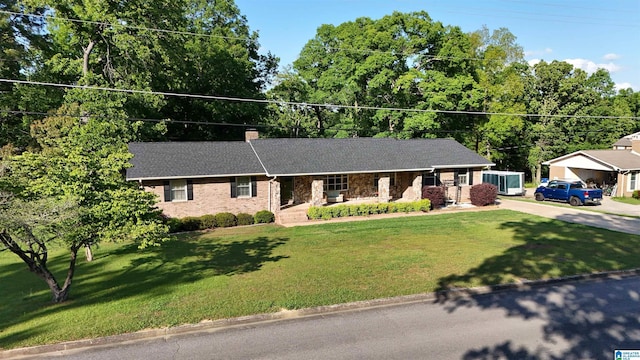 1111 Creek Trl, Anniston, AL 36206 - ranch-style house featuring a porch, concrete driveway, a chimney, and a front yard