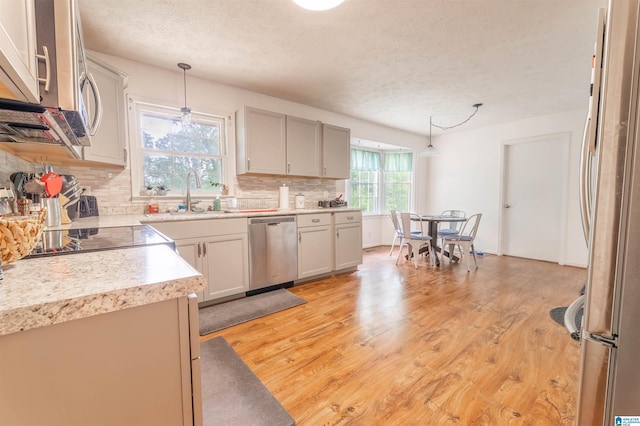 1111 Creek Trl, Anniston, AL 36206 - kitchen with a sink, a textured ceiling, decorative backsplash, and appliances with stainless steel finishes
