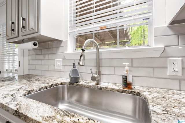 816 8th Cir N, Pell City, AL 35125 - kitchen view of a sink, decorative backsplash, light stone counters, and gray cabinetry