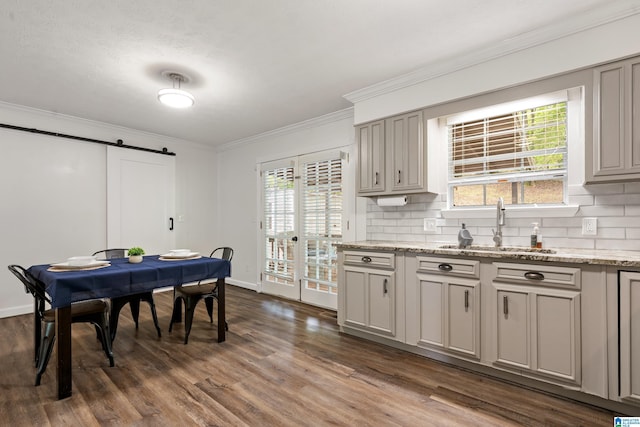816 8th Cir N, Pell City, AL 35125 - dining area featuring a barn door, ornamental molding, dark wood-type flooring, and baseboards