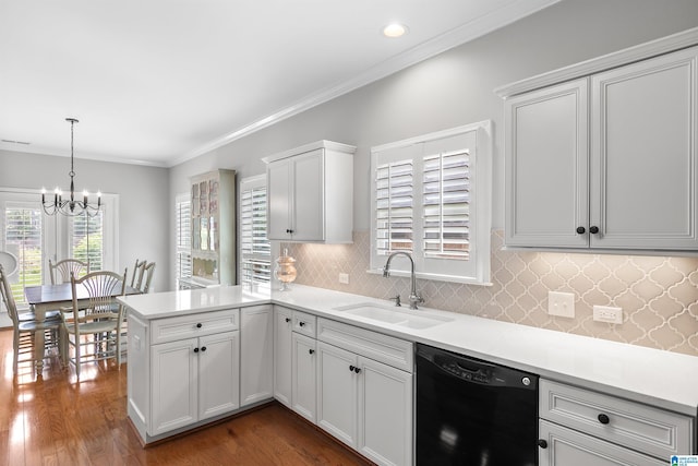 kitchen featuring black dishwasher, a sink, a chandelier, a peninsula, and light countertops