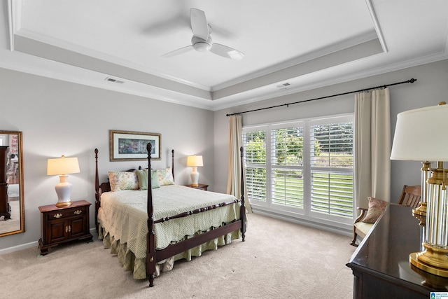 bedroom featuring a raised ceiling, ornamental molding, light colored carpet, and ceiling fan