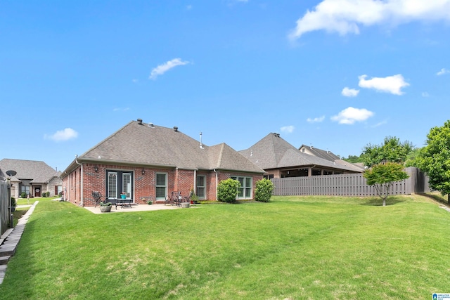 rear view of property featuring brick siding, a patio area, and a shingled roof