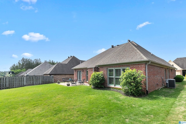 rear view of house featuring central air condition unit, brick siding, a patio area, and a shingled roof