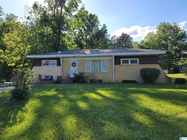 single story home featuring a front yard and brick siding