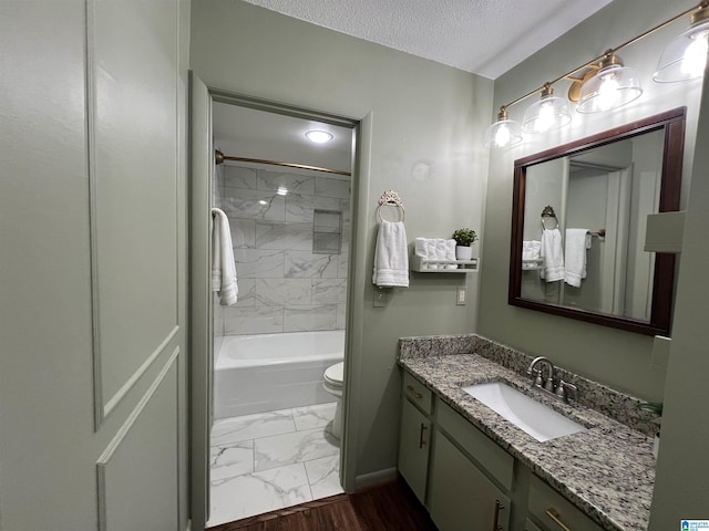 full bathroom featuring a textured ceiling, toilet, marble finish floor, vanity, and shower / washtub combination