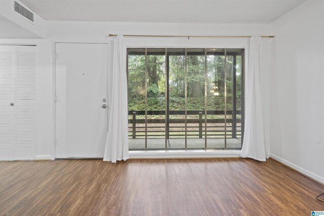unfurnished room with wood finished floors and baseboards