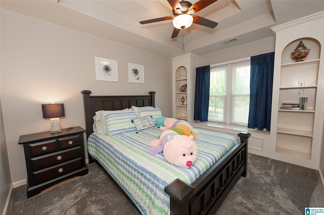 bedroom featuring a tray ceiling, a ceiling fan, visible vents, and dark carpet