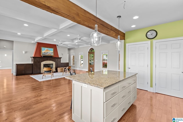 825 Dogwood Ln, Ashville, AL 35953 - kitchen with a fireplace, beamed ceiling, white cabinets, and light wood-style floors