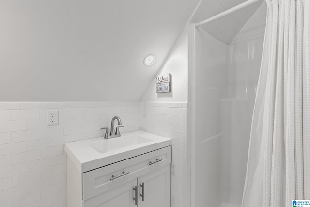 825 Dogwood Ln, Ashville, AL 35953 - bathroom with lofted ceiling, tile walls, a shower with curtain, wainscoting, and vanity