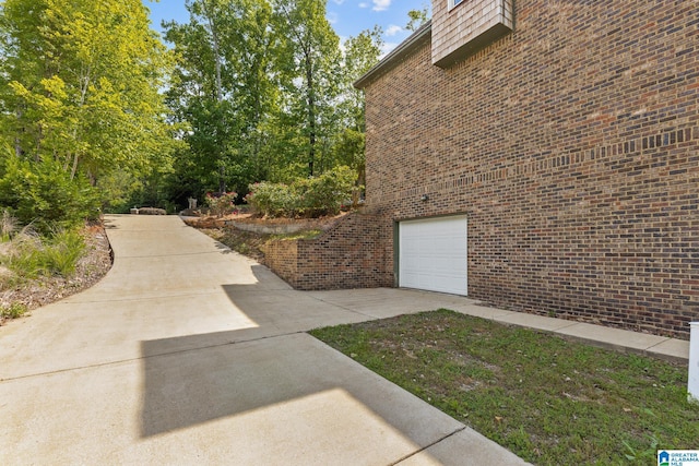 825 Dogwood Ln, Ashville, AL 35953 - view of property exterior featuring brick siding, driveway, and a garage