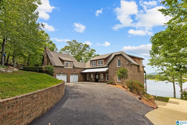 825 Dogwood Ln, Ashville, AL 35953 - view of front of home featuring an attached garage, a water view, a chimney, aphalt driveway, and a front lawn