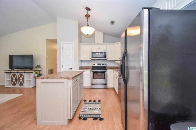 kitchen featuring appliances with stainless steel finishes, light wood-style flooring, vaulted ceiling, open floor plan, and white cabinetry
