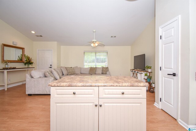 kitchen featuring light wood-style floors, open floor plan, light countertops, lofted ceiling, and recessed lighting