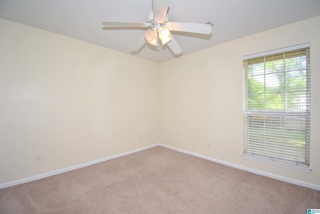 spare room featuring carpet floors, baseboards, and ceiling fan