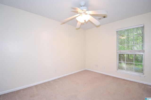 empty room featuring light carpet, baseboards, and ceiling fan