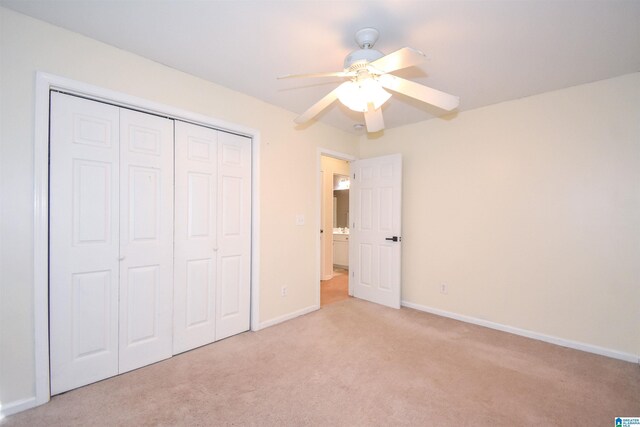 unfurnished bedroom with light colored carpet, a closet, baseboards, and ceiling fan