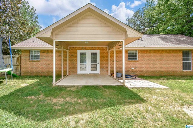 rear view of property featuring brick siding, a patio, and roof with shingles