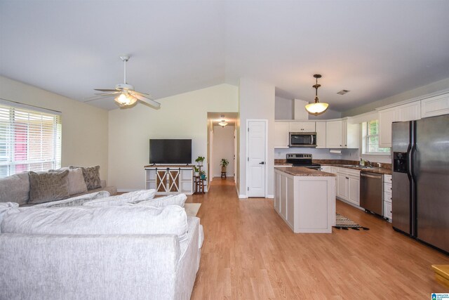 living area featuring lofted ceiling, a ceiling fan, light wood-type flooring, and baseboards