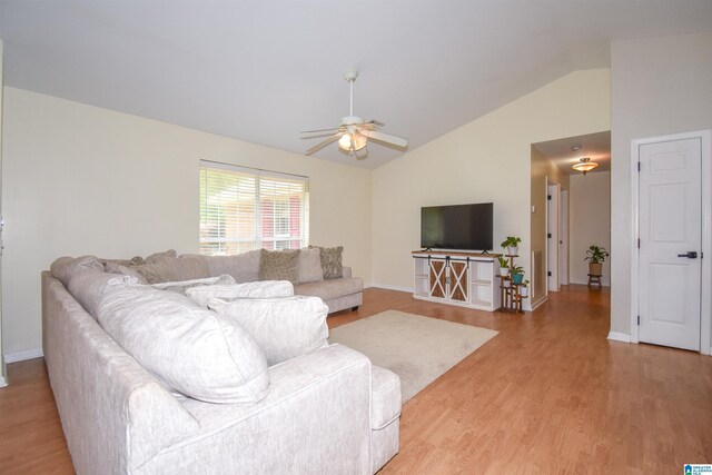 living area with lofted ceiling, light wood-style floors, a ceiling fan, and baseboards