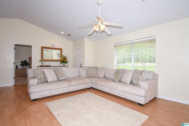 living area with vaulted ceiling, light wood finished floors, ceiling fan, and baseboards